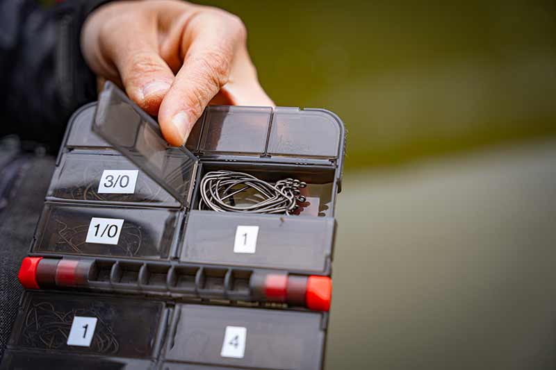 Caja de accesorios Fox Rage abierta con anzuelos organizados, ideal para la pesca de bass y depredadores.